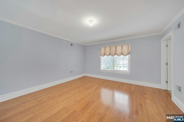 empty room with ornamental molding and light wood-type flooring