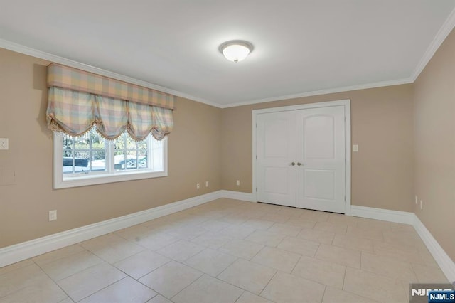 unfurnished bedroom with light tile patterned floors, crown molding, and a closet