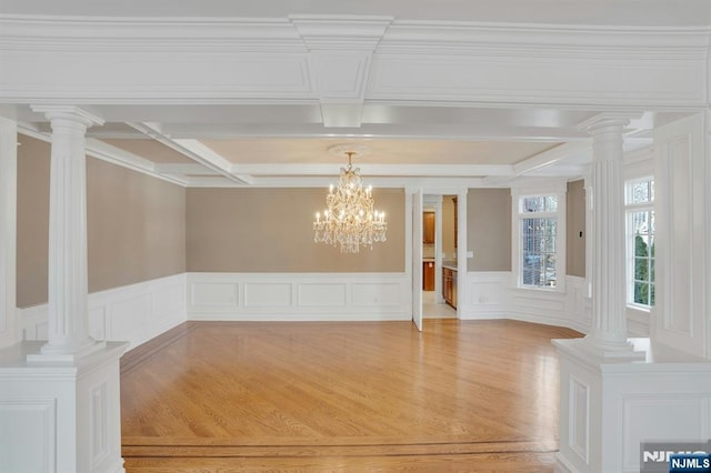 interior space with beam ceiling, light hardwood / wood-style floors, and ornate columns