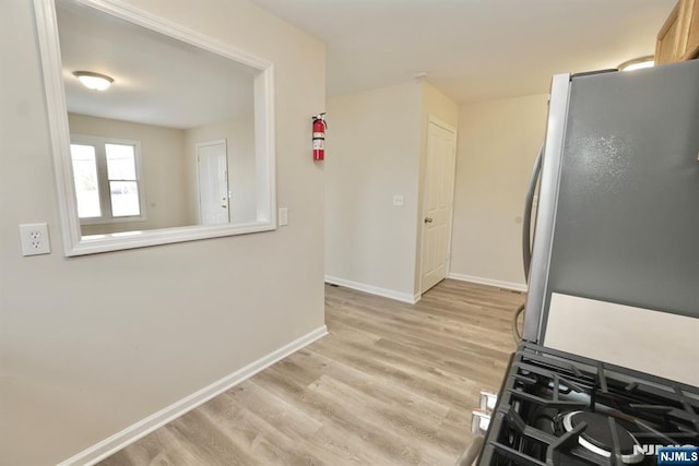 kitchen with stainless steel refrigerator and light hardwood / wood-style flooring