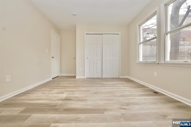 unfurnished bedroom featuring light hardwood / wood-style floors and a closet