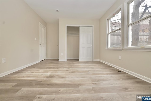 unfurnished bedroom with light hardwood / wood-style floors and a closet