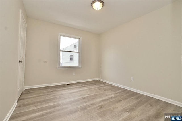 empty room with light hardwood / wood-style flooring