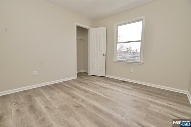 unfurnished bedroom with light hardwood / wood-style floors and a closet