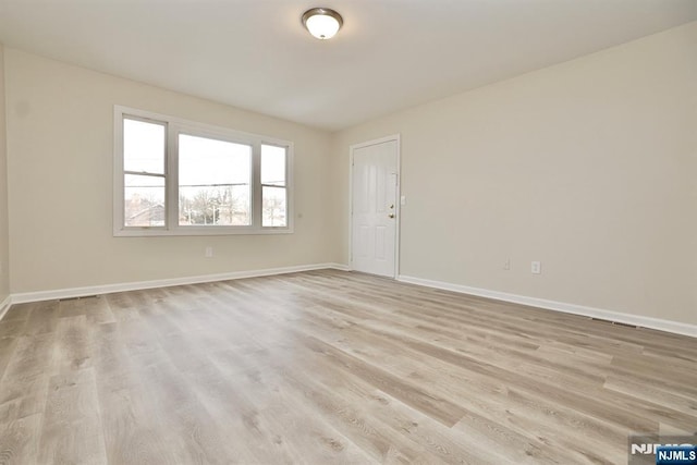 unfurnished room with light wood-type flooring