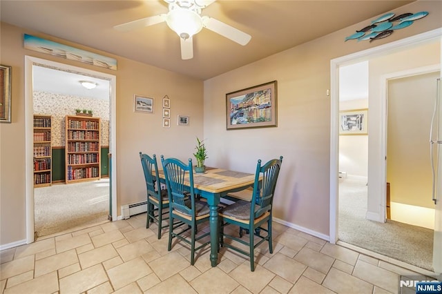 carpeted dining area featuring a baseboard heating unit and ceiling fan