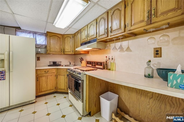 kitchen with white appliances and a paneled ceiling