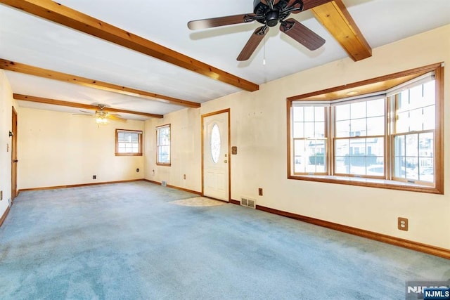 unfurnished room with beamed ceiling, light colored carpet, and ceiling fan