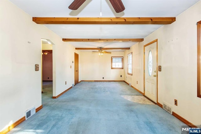 carpeted spare room featuring ceiling fan and beam ceiling