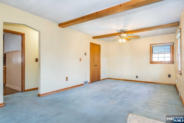 carpeted spare room with ceiling fan and beam ceiling