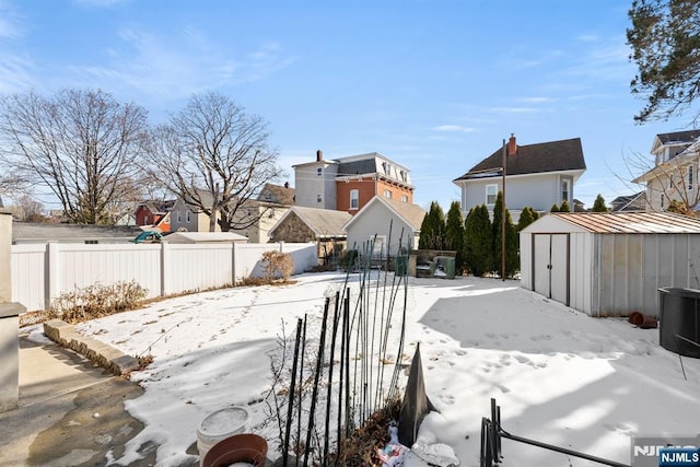 yard layered in snow with a shed