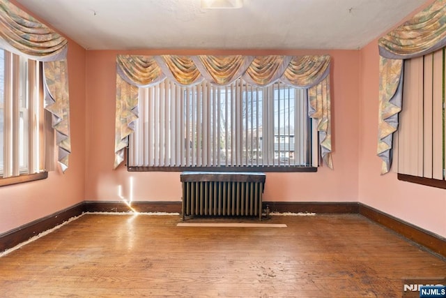 empty room featuring radiator heating unit and wood-type flooring