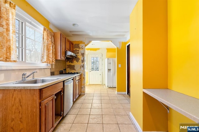 kitchen featuring sink, light tile patterned floors, white refrigerator with ice dispenser, and stainless steel dishwasher