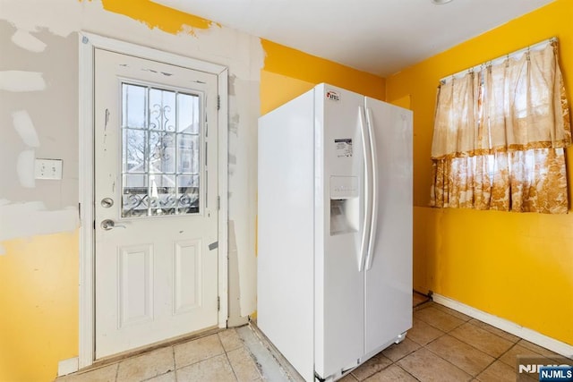 kitchen featuring light tile patterned flooring and white fridge with ice dispenser