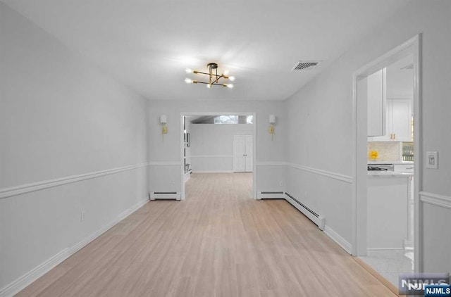 hallway featuring an inviting chandelier, light hardwood / wood-style floors, and baseboard heating