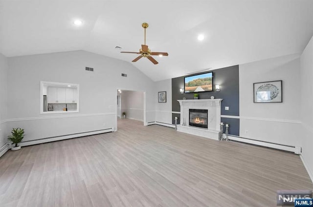 unfurnished living room with a fireplace, a baseboard radiator, vaulted ceiling, and light wood-type flooring