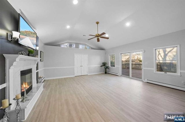 unfurnished living room featuring ceiling fan, vaulted ceiling, light hardwood / wood-style flooring, and a baseboard heating unit