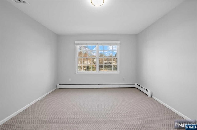 carpeted empty room featuring baseboard heating