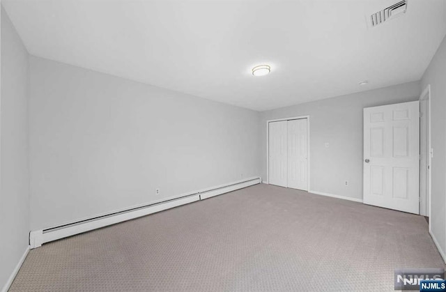 unfurnished bedroom featuring a baseboard radiator, a closet, and carpet flooring