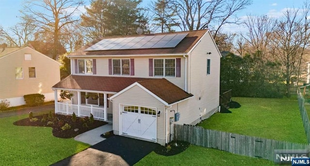 view of front facade featuring a front lawn, solar panels, and a porch