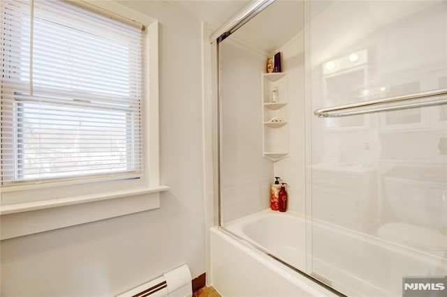 bathroom with combined bath / shower with glass door and baseboard heating