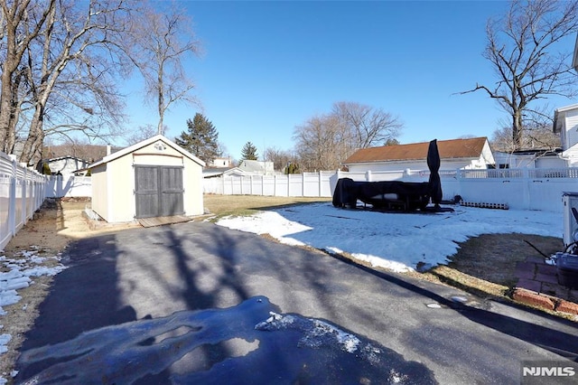 snowy yard with a storage shed