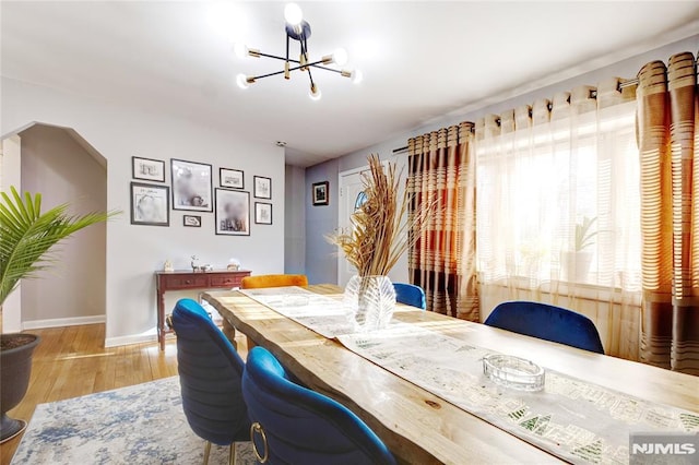 dining room with light hardwood / wood-style floors and a notable chandelier