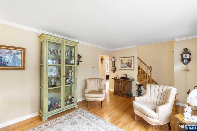 sitting room with ornamental molding and light hardwood / wood-style floors