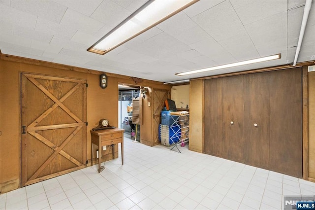 basement featuring wood walls