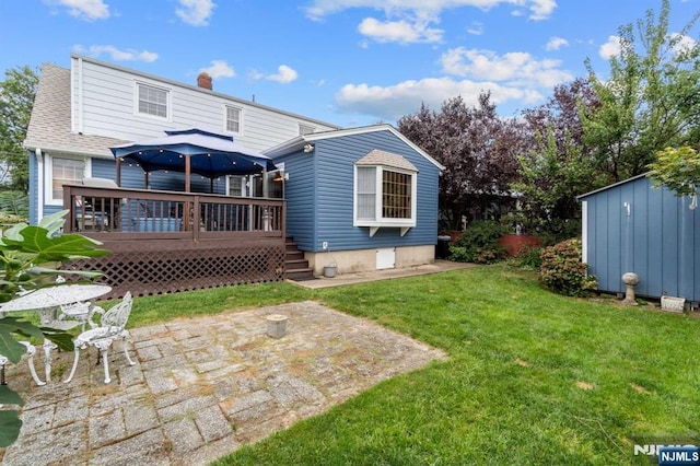 back of property with a wooden deck, a shed, a patio area, and a lawn