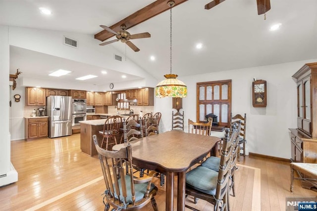 dining area featuring beam ceiling, high vaulted ceiling, ceiling fan, and light wood-type flooring