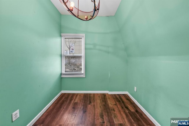 bonus room featuring a notable chandelier and dark hardwood / wood-style floors