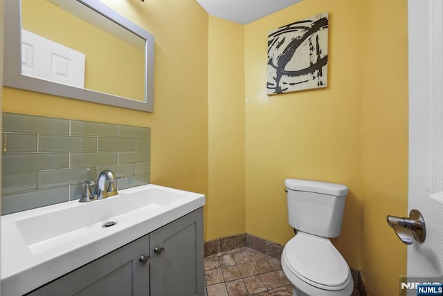 bathroom with vanity, tasteful backsplash, and toilet