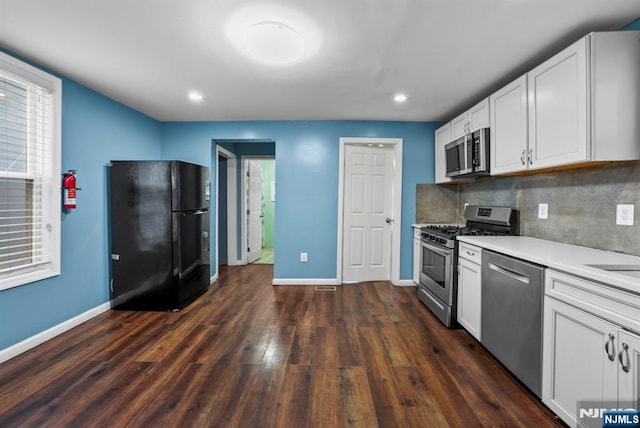 kitchen featuring stainless steel appliances, dark hardwood / wood-style flooring, decorative backsplash, and white cabinets