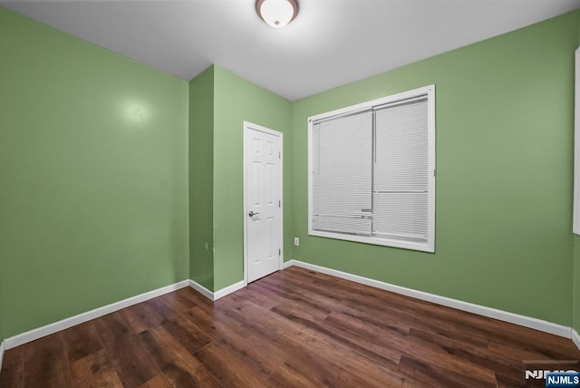 unfurnished bedroom featuring dark hardwood / wood-style flooring and a closet