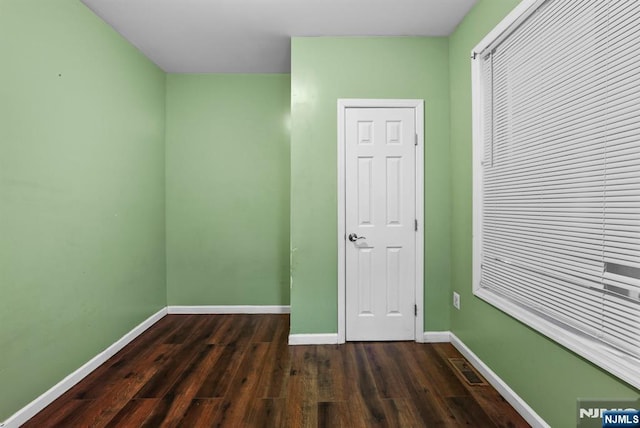 unfurnished bedroom with dark wood-type flooring