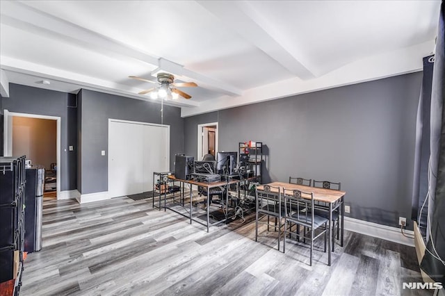 dining room featuring ceiling fan, baseboards, beamed ceiling, and wood finished floors