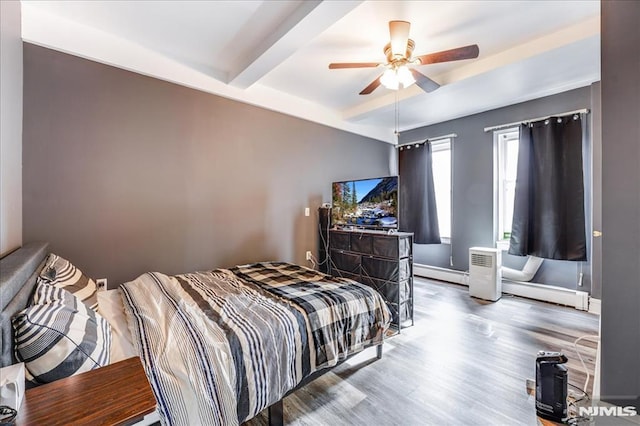 bedroom with ceiling fan, a baseboard radiator, wood finished floors, beamed ceiling, and baseboard heating