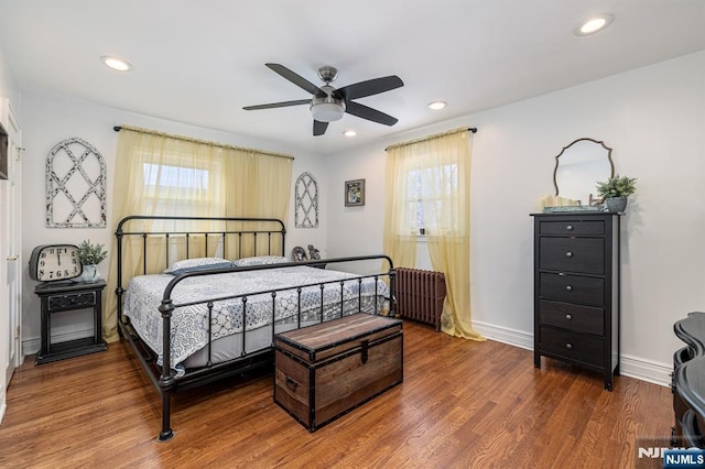 bedroom with radiator, hardwood / wood-style floors, and ceiling fan