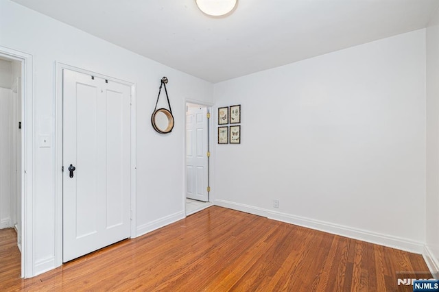 unfurnished bedroom featuring wood-type flooring and a closet