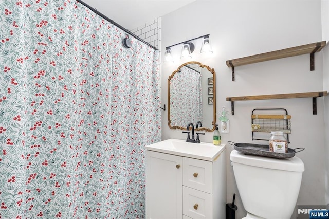 bathroom featuring vanity, toilet, and a shower with shower curtain