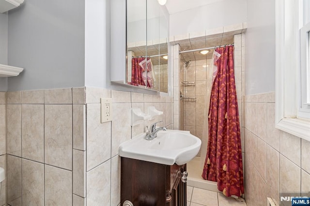 bathroom with tile patterned flooring, vanity, tile walls, and walk in shower