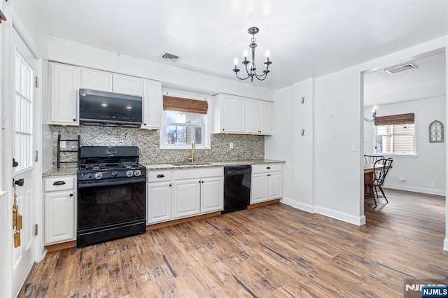 kitchen with white cabinetry, sink, an inviting chandelier, and black appliances