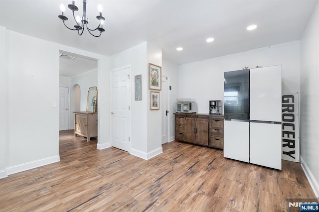 kitchen featuring white refrigerator, hardwood / wood-style floors, and an inviting chandelier