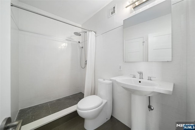 full bath with toilet, a shower stall, and visible vents