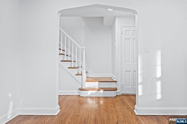 stairs featuring hardwood / wood-style floors