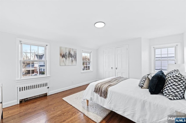 bedroom with radiator and wood-type flooring