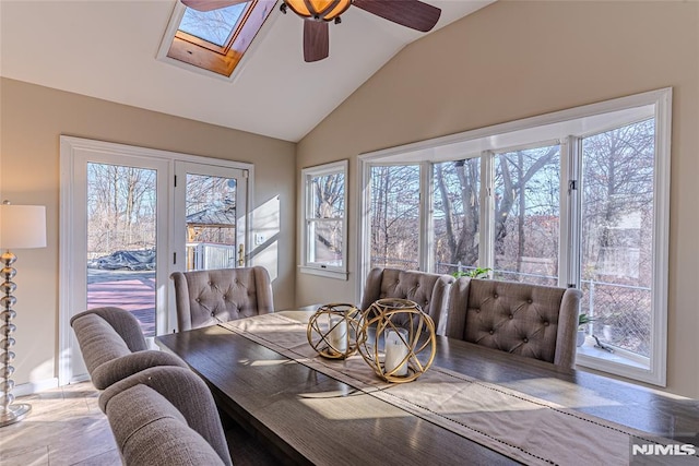 dining area featuring ceiling fan and vaulted ceiling with skylight