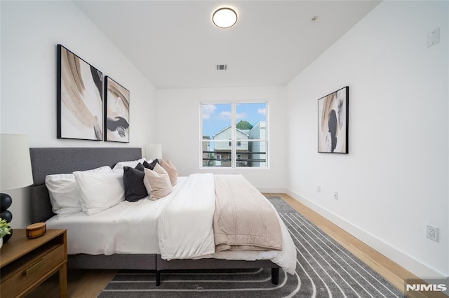 bedroom with dark hardwood / wood-style floors