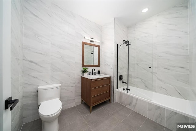 full bathroom with tiled shower / bath, vanity, toilet, and tile patterned flooring